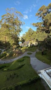 einen Fußweg durch einen Park mit Bäumen und einem Haus in der Unterkunft Green Park hermoso apartamento vista al lago in Punta del Este