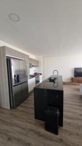 eine Küche mit einer schwarzen Insel in einem Zimmer in der Unterkunft Departamento en Angelópolis in El Gallinero