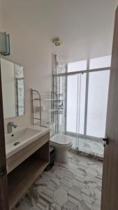 ein Badezimmer mit Waschbecken und Toilette und einem Fenster in der Unterkunft Departamento en Angelópolis in El Gallinero