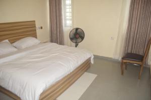 a bedroom with a bed with a fan and a window at Symphony Chalets 