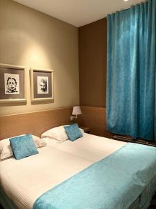 a bedroom with two beds and a window with blue curtains at Gravenhof in Beersel