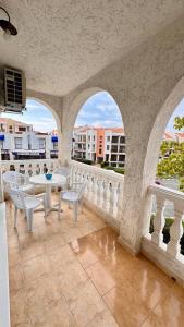 einen Balkon mit weißen Stühlen, Tischen und Fenstern in der Unterkunft Fantastic Apartment in Sveti Vlas in Sweti Wlas + 45 Fotos