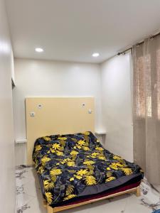 a bedroom with a bed with a yellow and black blanket at Filfila skikda in Rebaïb