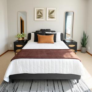 a bedroom with a large white bed and two mirrors at Aura in Covington