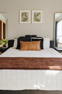 a bedroom with a large white bed with brown pillows at Aura in Covington