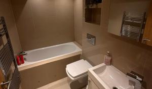 a bathroom with a tub and a toilet and a sink at Stylish Duplex Apartment in Liverpool City Centre in Liverpool