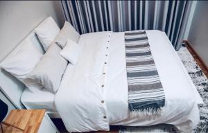 a white couch with a blanket on top of it at Apartment One bedroom Nairobi in Nairobi