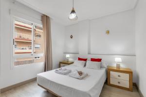 Un dormitorio blanco con una cama blanca y almohadas rojas. en Homely Apartments Las Salinas, en Torrevieja 31 fotos más