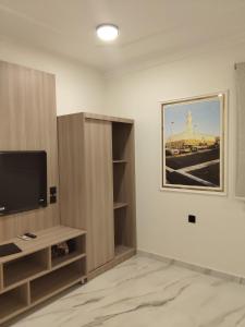 a living room with a flat screen tv and a entertainment center at قمة قباءلشقق in Al Madinah