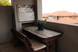 een houten tafel en een potplant op een balkon bij Nested at L&MX in Centurion