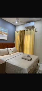 a bedroom with two beds and a window with a fan at Aquaview in Bijilo