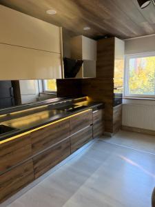 een grote keuken met houten kasten en een raam bij Apartament Str Crinului Cluj in Cluj-Napoca