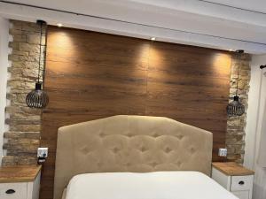 een slaapkamer met een bed en een houten wand bij Apartament Str Crinului Cluj in Cluj-Napoca