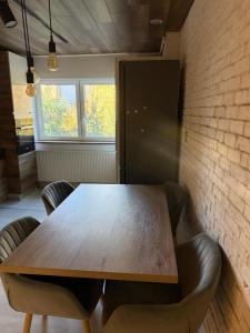 een houten tafel en stoelen in een kamer met een bakstenen muur bij Apartament Str Crinului Cluj in Cluj-Napoca