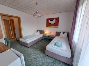 een slaapkamer met 2 bedden en een tafel met een bureau bij Boardinghouse-SWB in Villingen-Schwenningen