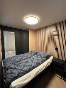 a bedroom with a bed with a blue and white comforter at Nice and modern apartment in Stavanger
