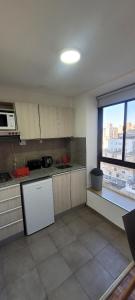 une cuisine avec un réfrigérateur blanc et une fenêtre dans l'établissement Departamento Plaza San Martín, à Córdoba
