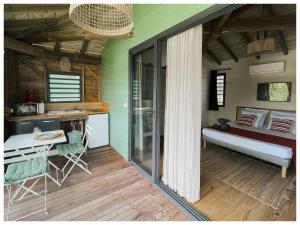 a room with a kitchen and a bed and a table at Les pilotis in Courcelles Sucrerie