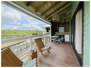 a balcony of a house with two chairs and a table at Les pilotis in Courcelles Sucrerie