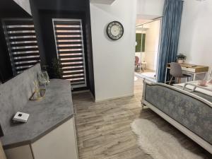 a bedroom with a bed and a clock on the wall at Quantum Apartament 22 in Craiova