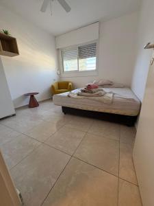 a bedroom with a bed and a tiled floor at חניתה 40 חיפה in Haifa