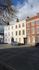 a large white building with a car parked in front of it at Burton Down Town Apartment in Burton upon Trent