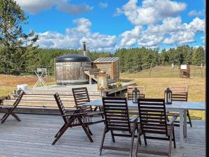 a picnic table and chairs on a deck with a grill at 9 person holiday home in Tystberga in Tystberga