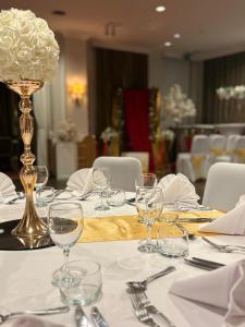 a table with wine glasses and a vase with flowers at Gravenhof in Beersel