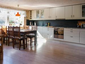 OrmarydにあるCharming Cottage by Sjunnaryd Lakeの白いキャビネットとテーブルと椅子のあるキッチン +13枚の写真