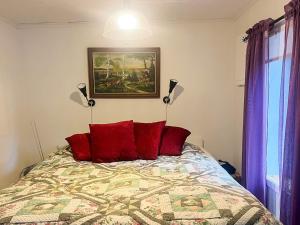 OrmarydにあるCharming Cottage by Sjunnaryd Lakeのベッドルーム1室(赤い枕と絵画付)