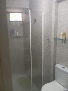 a glass shower in a bathroom with a toilet at Flat beiramar praia de Tabatinga in Conde
