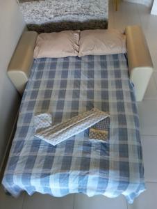 a bed with a plaid blanket on top of it at Flat beiramar praia de Tabatinga in Conde +7 photos