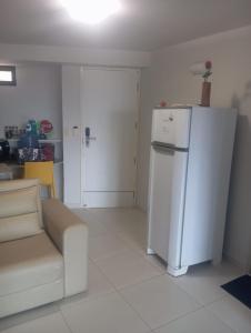 a living room with a refrigerator and a couch at Flat beiramar praia de Tabatinga in Conde