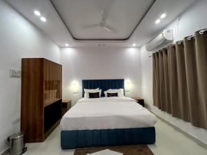 a bedroom with a large bed with a blue headboard at Hotel Dream Inn Khajuraho in Khajurāho
