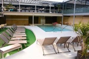 a pool with chairs and a table and a swimming pool at Hotel Platino Termas All Inclusive in Termas de Río Hondo