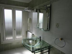 a bathroom with a glass sink and a mirror at Hôtel du Square d'Anvers in Paris