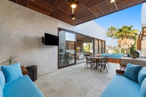an open living room with blue couches and a table at Peaceful Retreat with Pool – Ideal for Relaxation in Cruz de Huanacaxtle