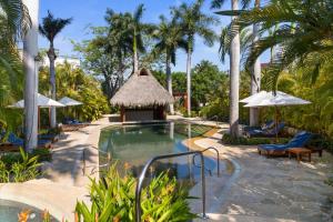 a pool at a resort with palm trees at Peaceful Retreat with Pool – Ideal for Relaxation in Cruz de Huanacaxtle