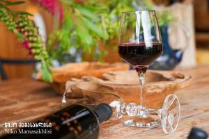 a glass of wine next to a bottle of wine at Niko Mamasakhlisi Guest House in Ozurgetʼi
