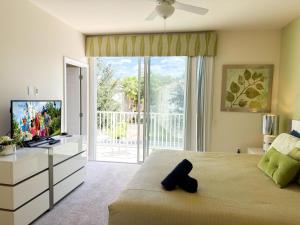 a bedroom with a large window and a television at Stylish 3-BR with Private Pool & Conservation View in Orlando +40 photos