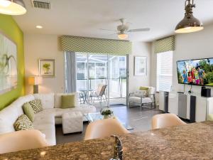 a living room with a white couch and a table at Stylish 3-BR with Private Pool & Conservation View in Orlando