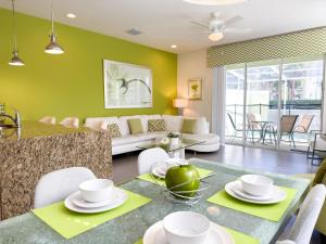 a living room with green walls and a table and chairs at Stylish 3-BR with Private Pool & Conservation View in Orlando