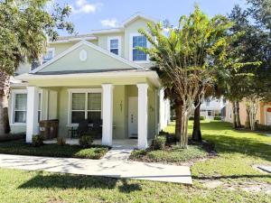 a white house with palm trees in front of it at Stylish 3-BR with Private Pool & Conservation View in Orlando