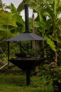 a black grill in the grass in a garden at Niko Mamasakhlisi Guest House in Ozurgetʼi +6 photos