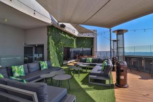 a living room with couches and a green wall at 423 Menlyn maine Apartment in Pretoria
