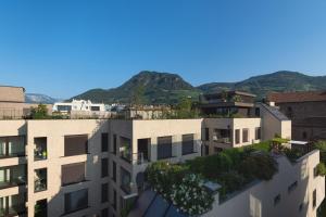 an apartment building with mountains in the background at SWEETHOME TALVERA - con Garage in Bolzano