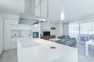 a white kitchen with a sink and a living room at SWEETHOME TALVERA - con Garage in Bolzano +26 photos
