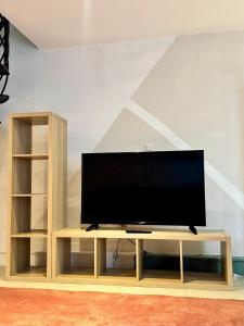a flat screen tv sitting on a wooden entertainment center at Yamohome in Brussels