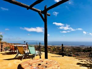 Una mesa y sillas en un patio con vista. en Las Casitas - Casa Higo, en Granadilla de Abona