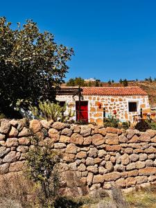 un muro de piedra frente a un edificio de ladrillo en Las Casitas - Casa Higo, en Granadilla de Abona
